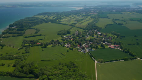 Beautiful-aerial-view-landscape-of-Brodten,-Germany,-flying-above-buildings-houses-with-Baltic-sea-on-background,-sunny-day,-circle-pan